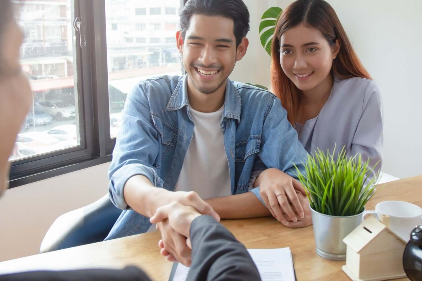 Man and woman shaking hands with property manager