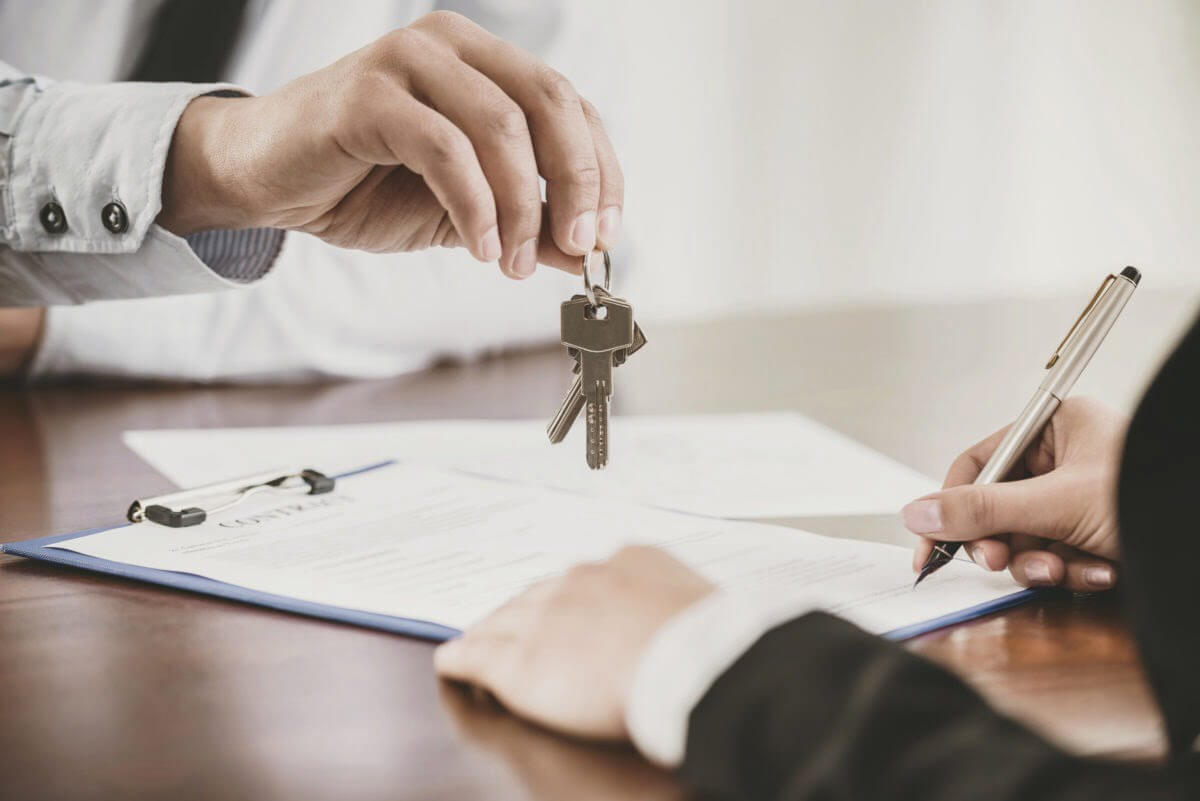 A person signs a lease and gets rental keys